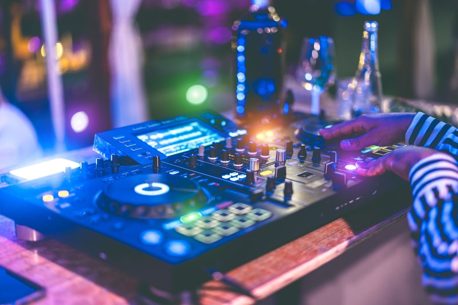 Cabina de DJ e iluminación de ambiente en plena fiesta