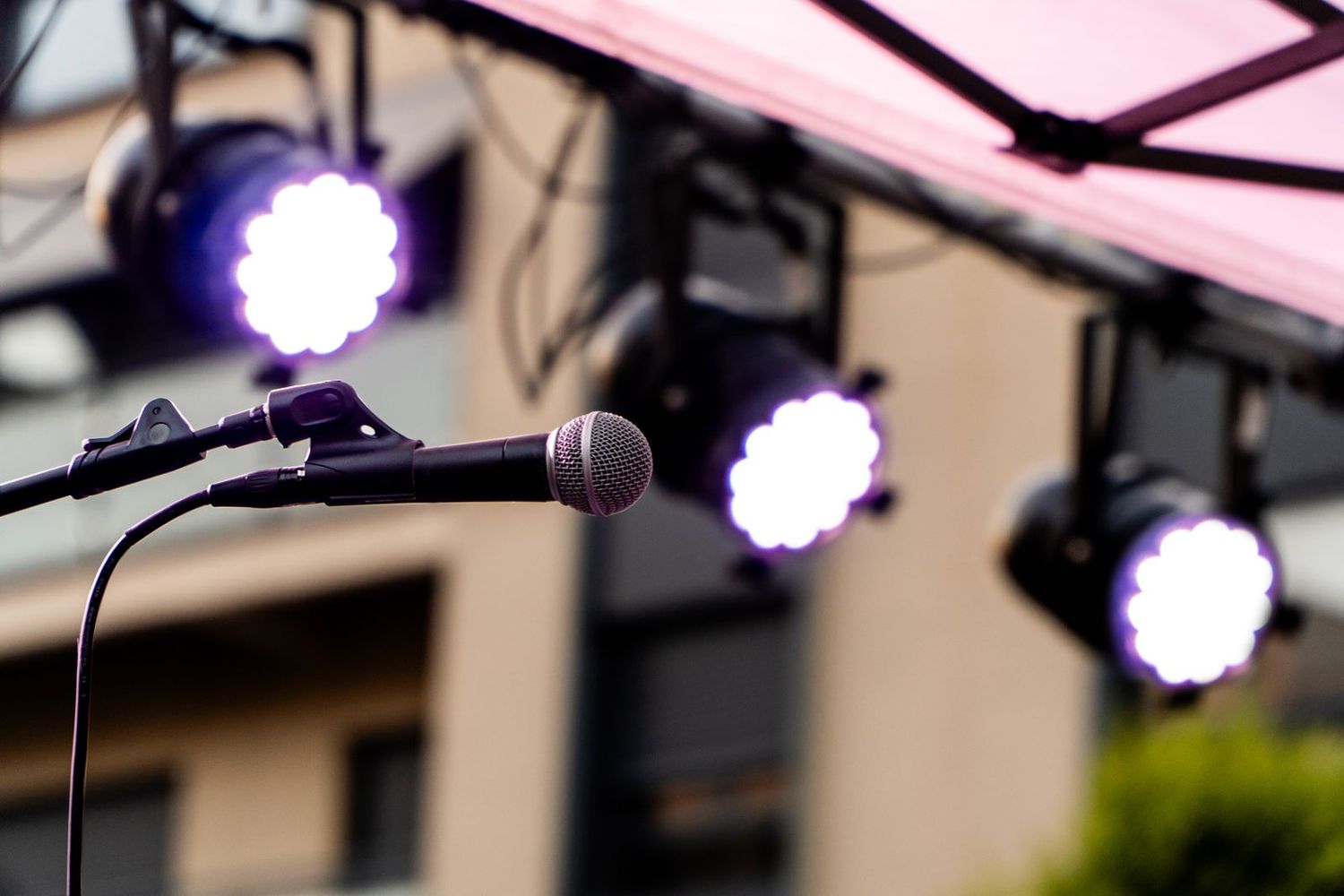 Micrófono en pie y focos LED de color en un montaje de exterior